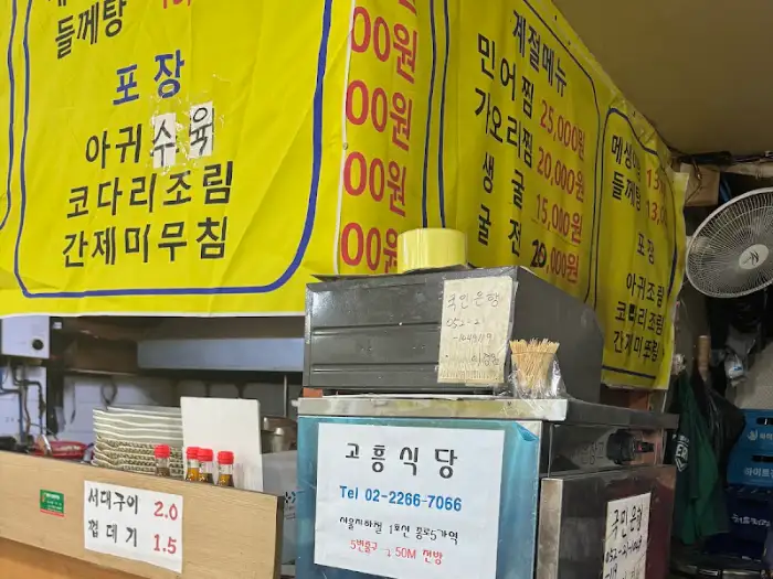 고흥식당의 메뉴 가격이 적힌 노란색 현수막