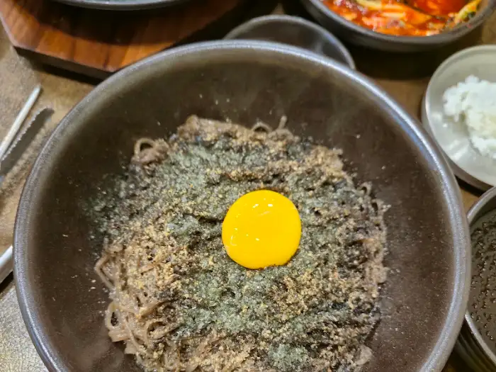 웅진달서돼지국밥 들기름막국수에 노른자를 섞는 모습