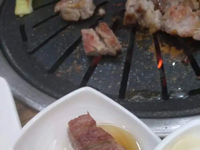 숯불 위에서 맛있게 익어가는 수라청의 두툼한 삼겹살