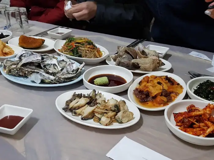 부동식당 테이블에는 다양한 종류의 푸짐한 해산물 요리와 반찬이 차려져 있습니다.