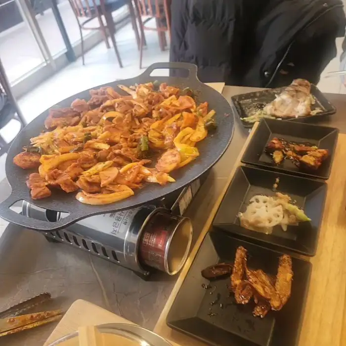불판 위에 푸짐하게 올려져 익어가고 있는 고기와 야채