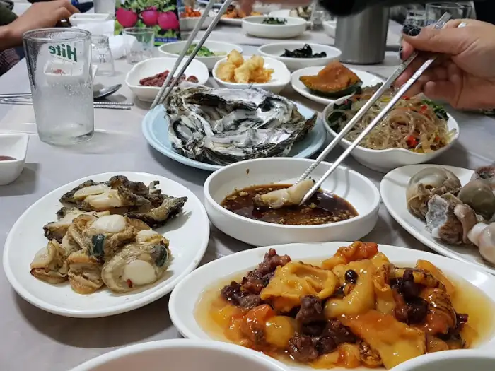 싱싱한 굴과 조개 요리가 메인 요리와 함께 푸짐하게 제공됩니다.