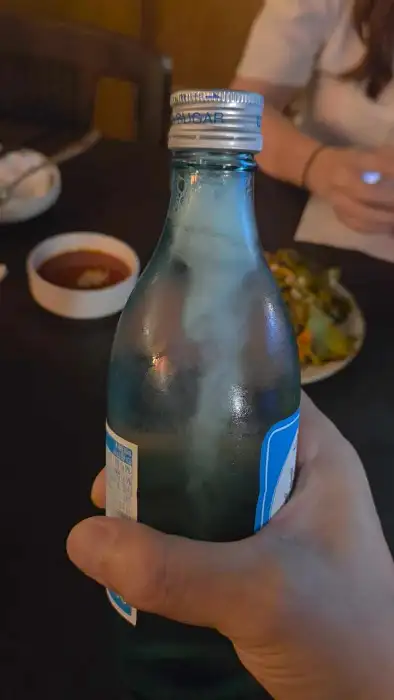 푸른빛의 소주병이 들려있는 모습