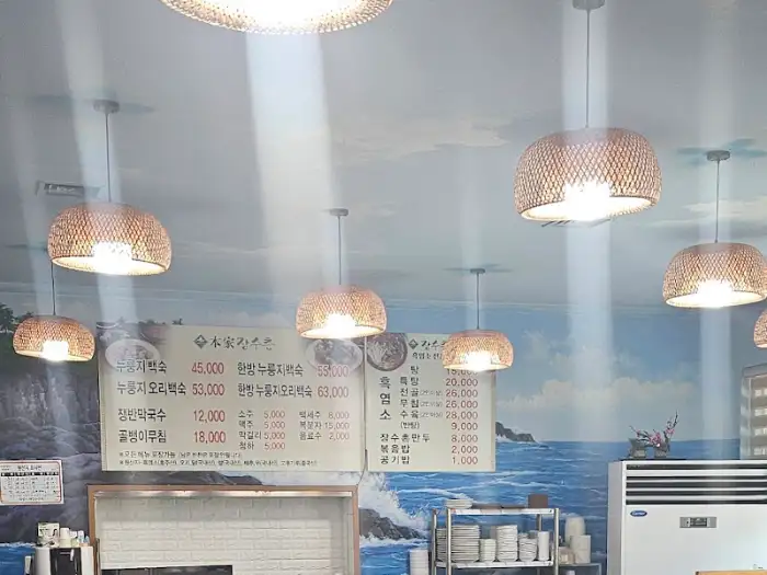본가장수촌 화성남양점 매장 내부의 샹들리에 조명과 메뉴판