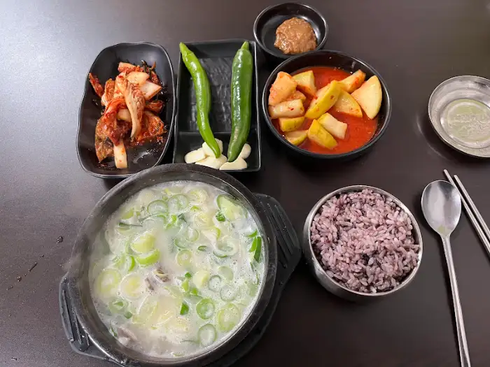 설렁탕과 곁들여 나온 김치, 깍두기, 밥, 고추 등의 모습