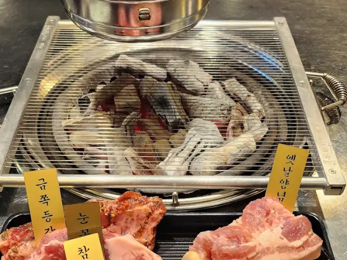 숯불 위 불판에 고기가 구워지고 있다.