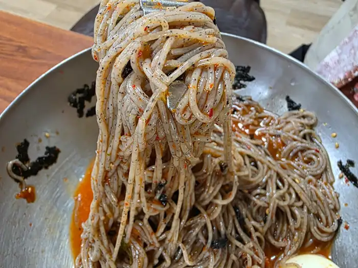 젓가락으로 집어 올린 막국수 가닥