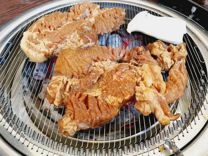 숯불 위에서 구워지고 있는 두툼한 갈비 덩어리