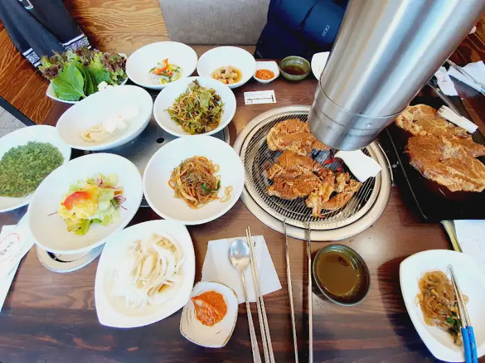테이블 위에 차려진 푸짐한 상차림, 고기와 쌈, 반찬들