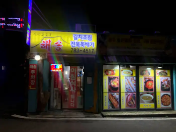해송 식당 외관, 저녁에 간판 불빛이 환하게 켜져 있습니다.