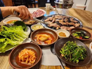 낙동생오리에서 푸짐하게 차려진 생오리 구이와 다양한 반찬 모습