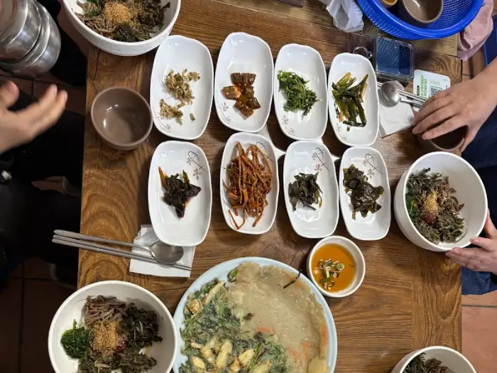 테이블에 푸짐하게 차려진 산채정식과 오징어전, 씨껍데기술