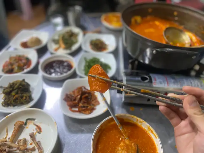 나연식당의 푸짐한 닭볶음탕과 다양한 밑반찬이 준비된 상차림