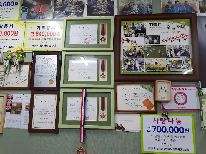 나연식당 벽면에 걸린 각종 방송 출연 및 감사패, 기부 증서 사진들