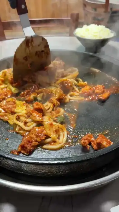 주걱으로 닭갈비를 볶고 있는 주방 직원의 모습