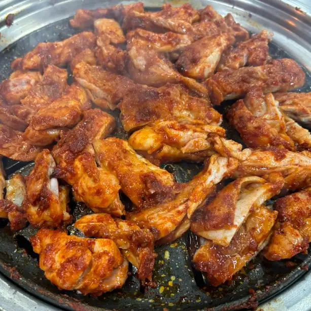 옥선가숯불닭갈비막국수의 숯불 닭갈비가 숯불 석쇠 위에 가득 올라가 있는 모습