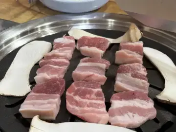 OK식육점식당의 신선한 삼겹살이 불판 위에서 구워지고 있는 모습
