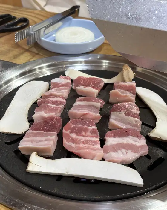 OK식육점식당의 신선한 삼겹살이 불판 위에서 구워지고 있는 모습