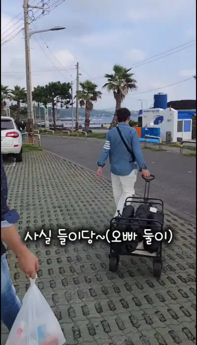 해변가를 따라 짐을 싣고 이동하는 사람