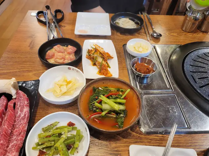 프라임소야 숯불소고기 성남본점의 다양한 반찬과 소고기, 숯불 구이 모습