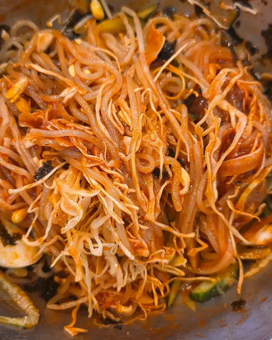 빨갛게 양념된 라볶이 위에 콩나물과 면이 푸짐하게 담겨 있습니다.