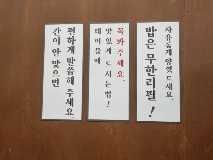 밥은 무한리필, 맛있게 드세요 등 안내 문구가 적힌 세 장의 안내판