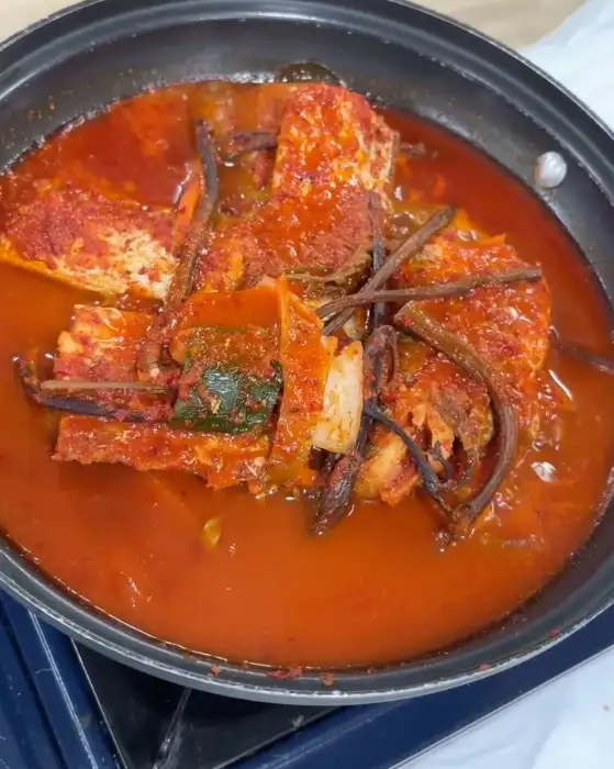 김치 양념처럼 보이는 붉은 양념 속에 푹 익은 갈치 토막과 채소가 담겨 있는 냄비