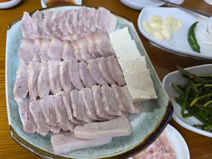 다양한 쌈 채소와 함께 푸짐하게 차려진 보쌈 한 접시