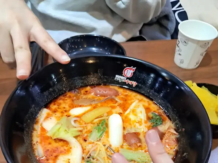 마라탕을 앞에 두고 손가락으로 가리키며 대화를 나누는 모습