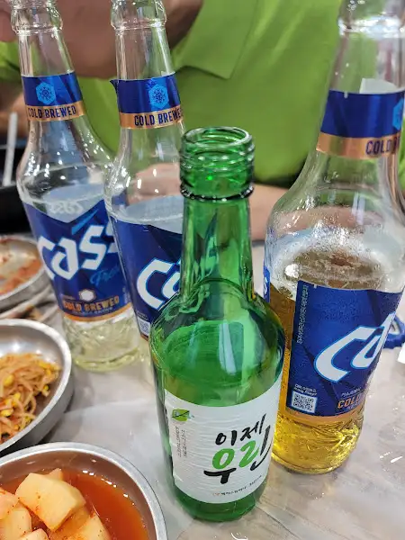 테이블 위에 소주병과 맥주병들이 놓여있는 모습
