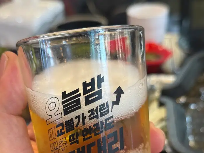 맥주잔에 담긴 시원한 맥주와 올래철판곱창