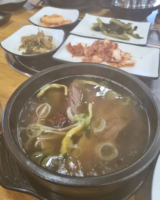 새하얀 쌀밥이 담긴 솥과 함께 여러 가지 반찬이 차려진 식탁