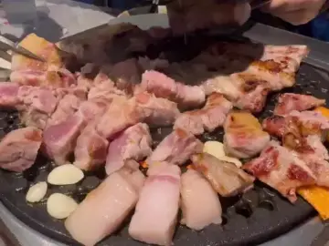 제줏간 전주혁신도시점의 두툼한 삼겹살이 불판 위에서 맛있게 구워지고 있는 모습