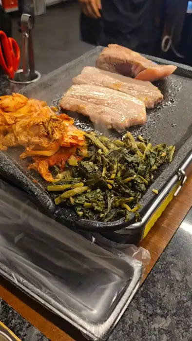 직원이 삼겹살을 먹기 좋은 크기로 잘라주는 모습