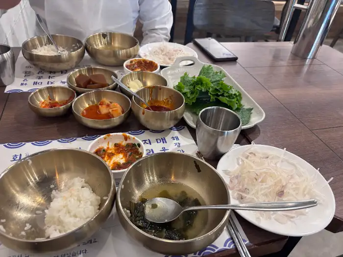 테이블에 놓인 다양한 밑반찬과 밥, 미역국