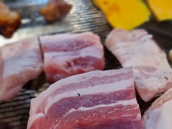 식껍 서대문역 직영점 불판 위에 놓인 생 삼겹살 덩어리