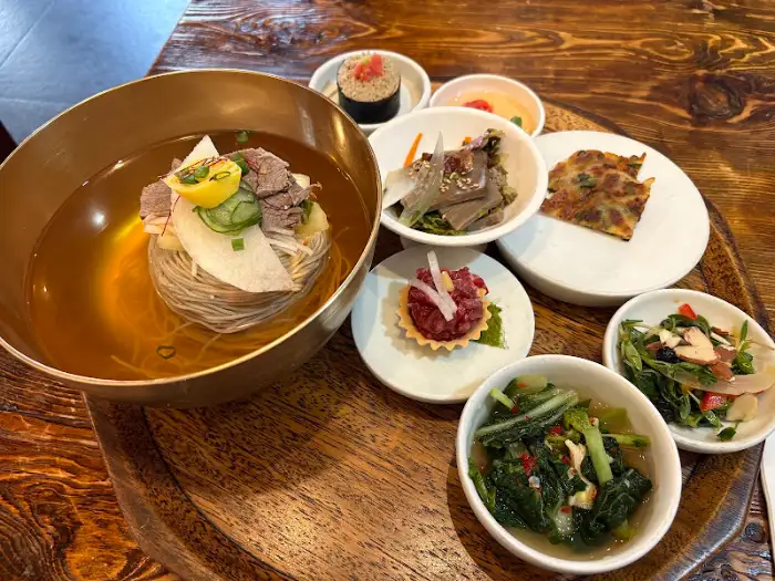 서관면옥 통창 너머로 보이는 도심 뷰와 함께 플레이팅된 냉면
