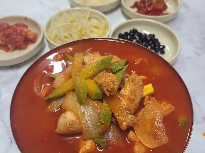 명화식육식당의 정갈한 밑반찬들, 다양한 장아찌와 김치가 보입니다.