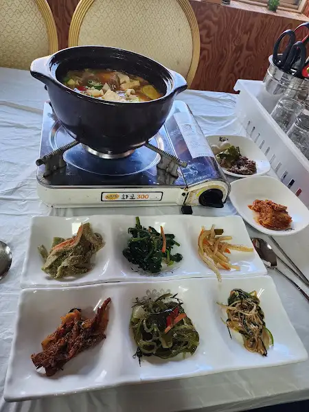 정갈하게 담긴 6가지의 밑반찬과 끓고 있는 샤브샤브 냄비