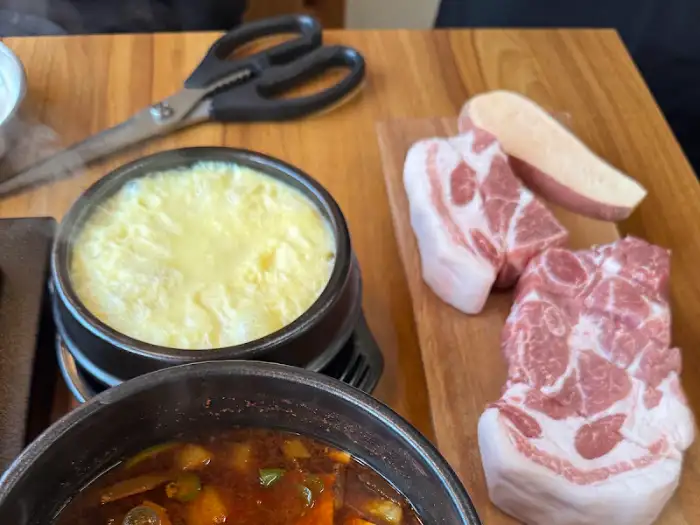 식사 메뉴로 나온 계란찜과 찌개, 그리고 곁들여진 고기