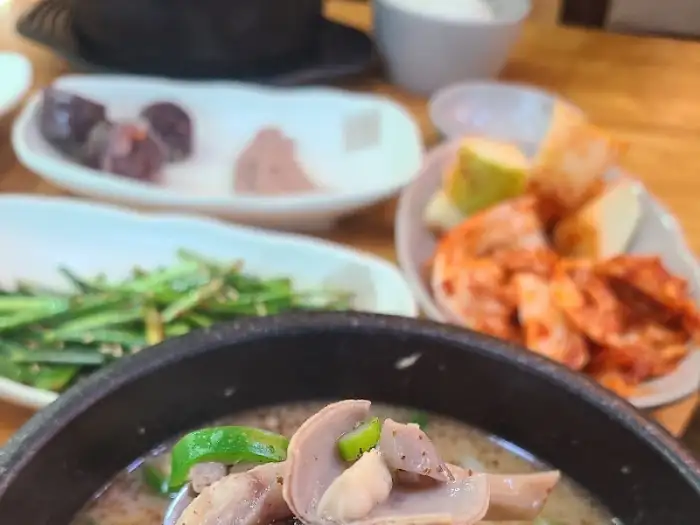 순대국 국물에 밥을 말아 김치와 함께 먹는 모습, 맛있는 한 끼 식사가 돋보입니다.