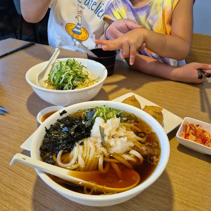 주도면밀우동집 테이블에 놓인 여러 우동과 사이드 메뉴
