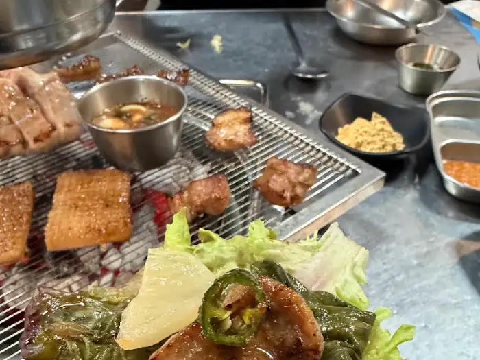 테이블 위에 세팅된 다양한 곁들임 반찬과 고기