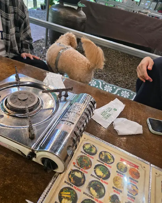 테이블 위에 놓인 백숙 냄비와 여러 밑반찬들