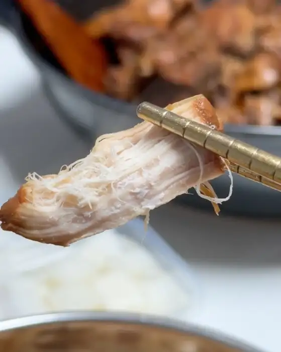집게로 집어 올린 부드러운 닭고기 살