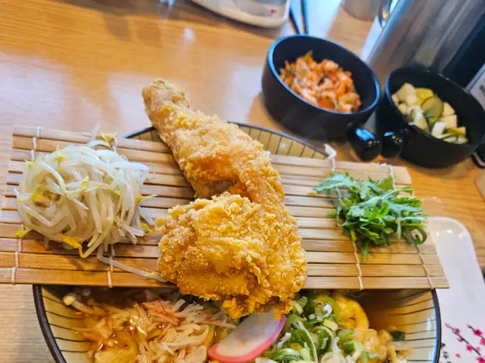 우동과 함께 제공되는 닭다리 튀김과 샐러드 모습