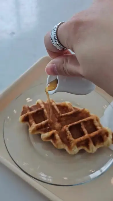 바삭한 크로플에 시럽을 뿌리는 모습