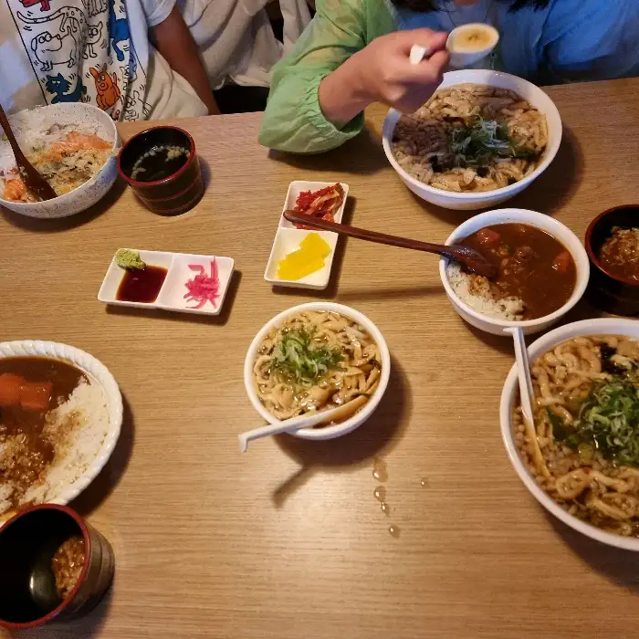 테이블에 차려진 다양한 우동 및 덮밥 메뉴들