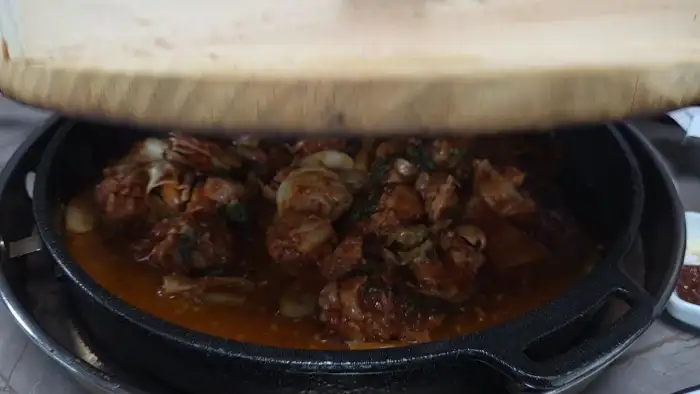 나무 뚜껑을 열자 김이 피어오르는 닭갈비 냄비