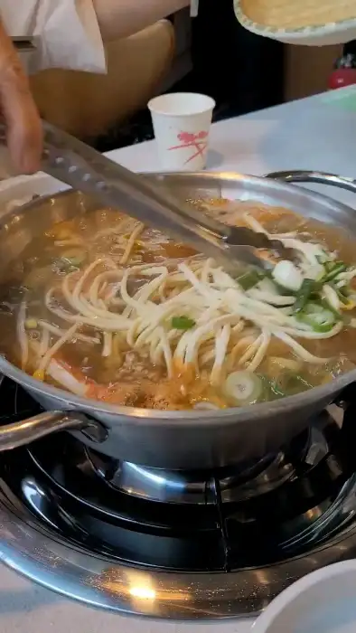 손정보쌈 가산디지털단지역점의 얼큰한 칼국수 전골이 끓고 있는 모습